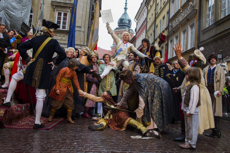 Rekonstrukcja historyczna święta Konstytucji 3 Maja z uczestnikami w strojach z XVIII wieku na brukowanej ulicy Starego Miasta