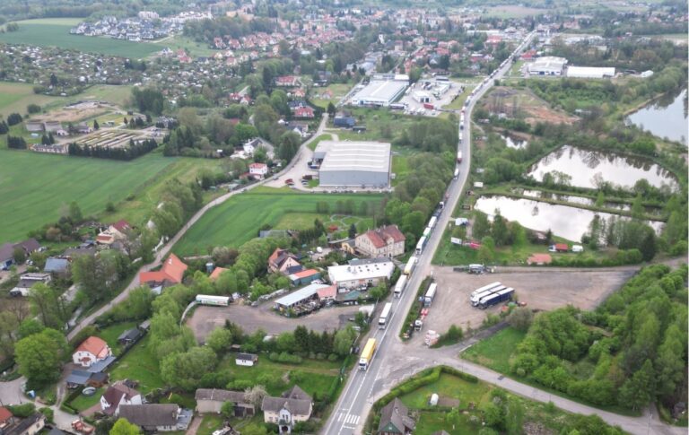 Długa kolumna samochodów ciężarowych stojących w korku na drodze krajowej nr 8 w Kudowie-Zdroju, widok z lotu ptaka.